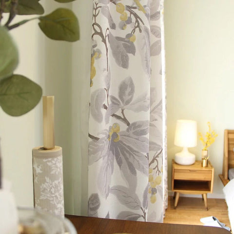 Cortina blanca con estampado de flores, gris y amarillo.