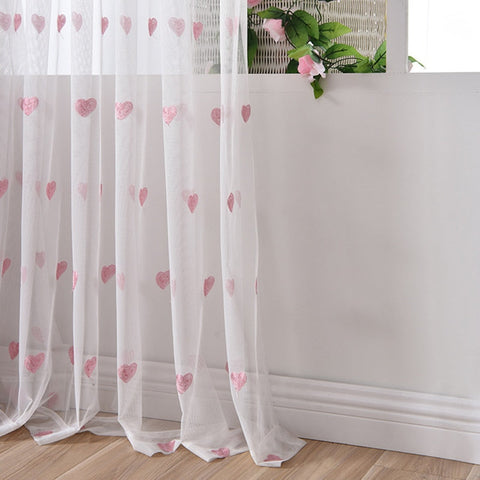 Cortina transparente con estampado de corazones.