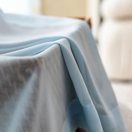 a bed covered with a blue sheet and a white chair