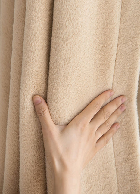 a person's hand on the curtain of a window
