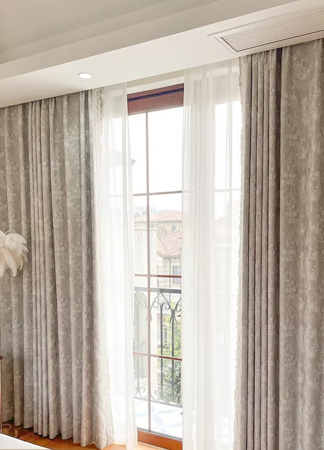 a bedroom with a bed and a window with curtains