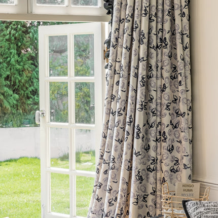 a window with a curtain and a chair in front of it