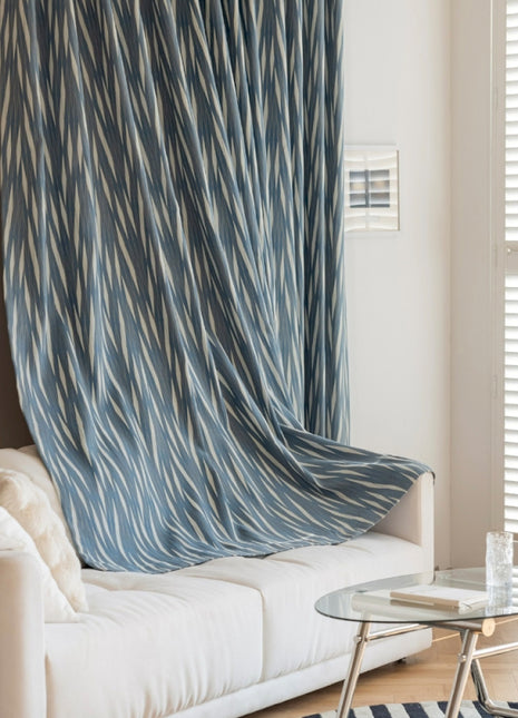 a living room with a white couch and a blue curtain