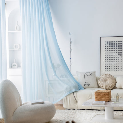 a living room with a white couch and blue drapes