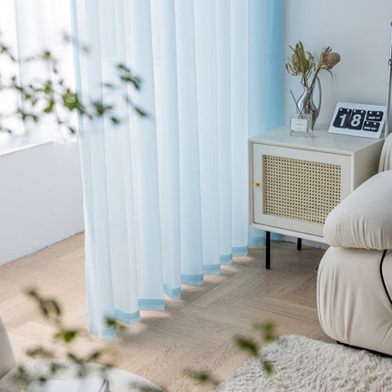 a living room with a white couch and blue curtains