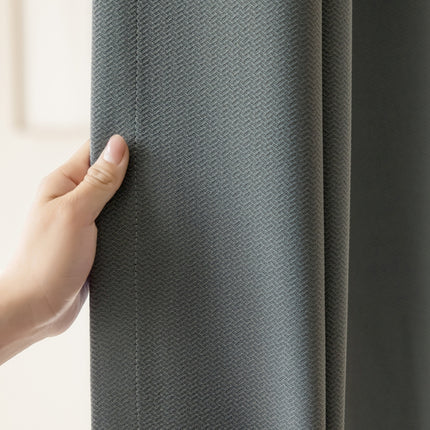 a person is holding a curtain in their hand
