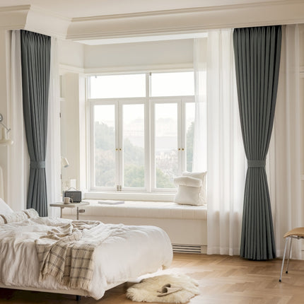 a bedroom with a large window and a white bed