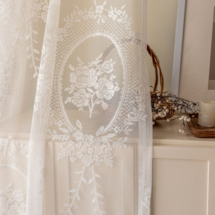 a white curtain with a flower design on it