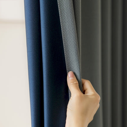 a person holding a curtain with their hand