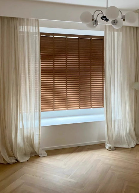 an empty room with a window and a chandelier